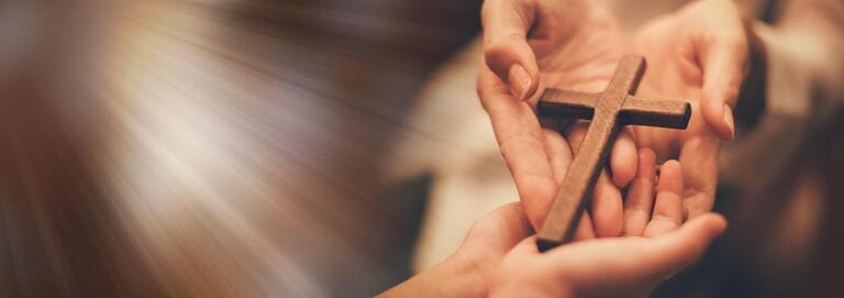 Woman's hand with cross.Concept of hope, faith, christianity, religion, online church.